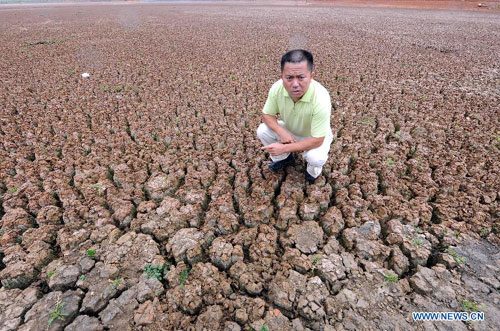 Wang Jun, an official in charge of local water management, shows the dried-up reservoir in Yunnan Province, Aug. 23, 2011. 