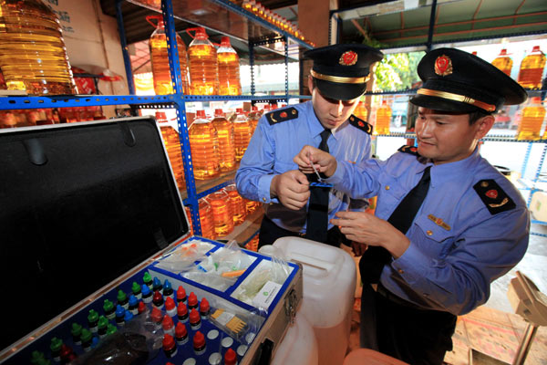 Inspectors with the commercial authority in Rongan county, South Chinas Guangxi Zhuang autonomous region, test samples of cooking oil on Oct 17. TAN KAIXING / FOR CHINA DAILY