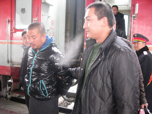 Ji Siguang (left), a suspect in a robbery who played roles in many TV plays while he was at large, is taken to Qiqihar, Heilongjiang province, by police on Tuesday. Provided to China Daily