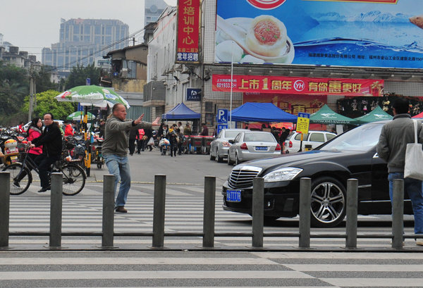 Uncle Ma forces cars to stop in front of zebra crossing in Fuzhou on Monday using tai chi.[Whats On Xiamen photo/CFP] 