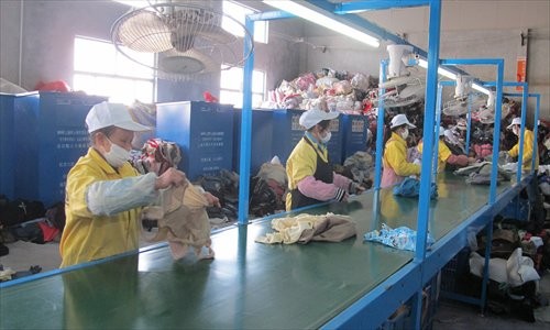 Workers sort used clothes on the processing line at the recycling company Shanghai Yuan Yuan Industry. Photo: Chen Xiaoru/GT