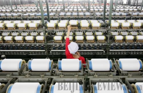 Fast rolling: a worker at the Zhejiang Yongxin Group plant, a leading textile manufacturer in China.