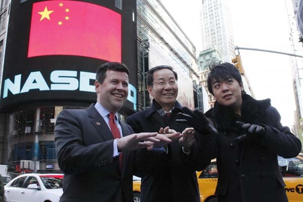 Chinese Consul General in New York Sun Guoxiang, pianist Lang Lang, and Nasdaq Senior Vice-President Robert McCooey pretend to play piano in front of the Nasdaq MarketSite screen.