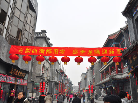 With the Chinese Spring Festival drawing near, the shops and restaurants along the tourist shopping hub of Qianmen street are decorated with red lanterns. Beijing's popular pedestrian street is an area where many time-honored brands and traditional handicraft sellers gather. It's a popular hangout place for Beijingers and tourists alike. [Photo:CRIENGLISH.com]