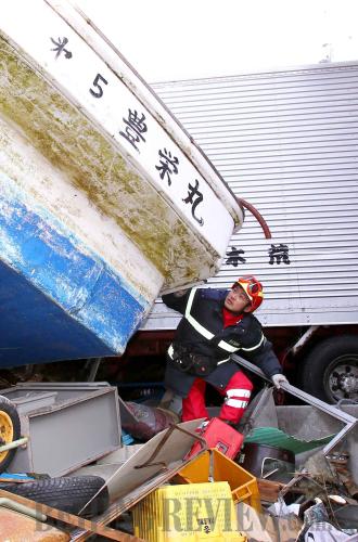 A member of the Chinese International Search and Rescue Team searches for survivors in quake-hit Ofunato, Japan on March 17, 2011. More than 1.25 million people follow the team on Sina Weibo, China's 
