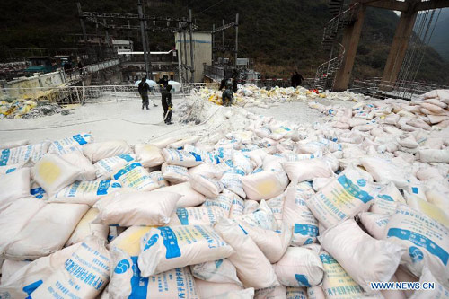 Firefighters work to put in chemicals made from dissolved aluminum chloride to neutralize the polluted Longjiang River in Hechi City, south China's Guangxi Zhuang Autonomous Region, Jan. 26, 2012. 