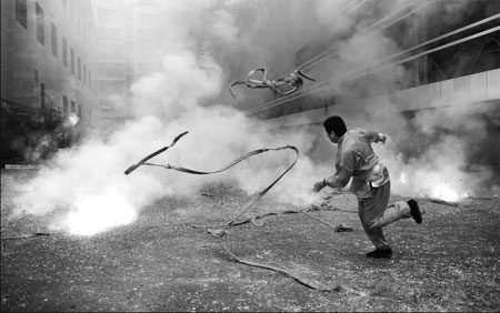 A man from an investment company throws away a string of firecrackers on Sunday, the first working day after the Spring Festival holiday, in Wuhan, Hubei province. Shepherd C. Zhou / for China Daily