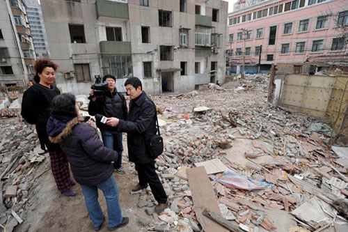 Residents at the Beizongbu Hutong in Beijing's Dongcheng district on Saturday talk about the demolition of Liang Sicheng's former residence to a reporter with China Central Television. Li Wenming / fo