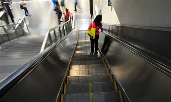 A woman stands on an escalator at Beitucheng Subway Station. An escalator death in Xidan yesterday highlights how little people know about safety on these machines. Photo: CFP 