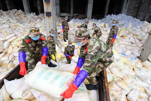 Police officers of Liuzhou, in the Guangxi Zhuang autonomous region, move bags of aluminum chloride, which can neutralize heavy metal pollutants, to ensure safe river water. Huang Xiaobang / Xinhua 