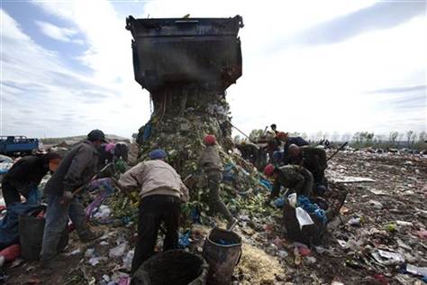 Chinese women and men search through garbage for recyclable materials at a dump site in Changchun in northeastern China's Jilin province. [Photo: Associate Press]