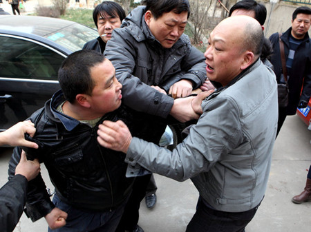 Wang Hui (L), husband of Zhang Miao, tussles with Ma Yanming (R), attorney of Yao Qingwei outside a residential building where Yao lives in Xi'an, Northwest China's Shaanxi province, Feb 8, 2012. Wang, along with Zhang Pingxuan (father of Zhang Miao) and his attorney Zhang Xian came to Yao's house on Wednesday to collect 200,000 yuan compensation promised by the latter for his son's hit-and-run accident that killed Zhang Miao on Oct 20, 2010. [Photo/CFP]