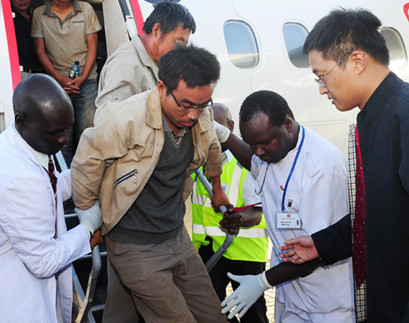An injured Chinese worker gets off a plane with the help of medical personnel at Wilson Airport in Nairobi, Kenya, on Feb 7. All of the 29 Chinese workers kidnapped by Sudanese anti-government forces were released and arrived in Nairobi safe and sound. Di