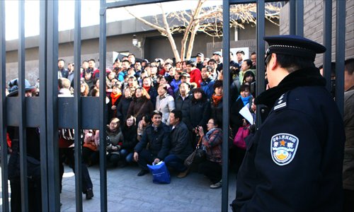 A police officer watches while parents gather for photos in the courtyard of the Ministry of Education's petitions office yesterday.Photo: Guo Yingguang/GT 