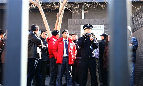 A uniform officer videotapes the peaceful gathering outside the Ministry of Education yesterday, when parents appealed for the removal of the hukou restrictions that ban their children from taking the college entrance exams in Beijing. Photo: Guo Yingguan