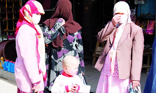 Three Uyghur women and a child at a market in Kashi, Xinjiang Uyghur Autonomous Region. Photo: CFP 