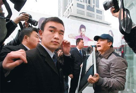 Zou Hongqing demonstrates in front of an Apple outlet in Shanghai on Thursday. Zou demanded a refund after purchasing what he claimed was a defective product from the tech giant. [Photo by Yong Kai / for China Daily]