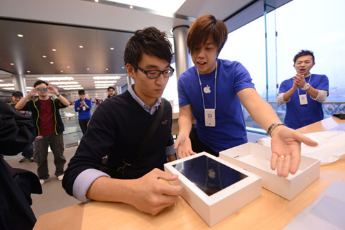 An employee at the Hong Kong Apple Store presents the new iPad to a customer on Friday. Gadget lovers in Australia, Japan and Hong Kong became the first people to snap up the new iPad. Aaron Tam / Agence France-Presse