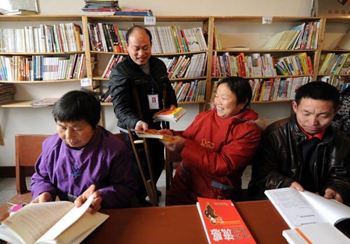 Lei Zhigang (second left), who has difficulty walking, is one of 105 people with disabilities who have been given jobs as librarians across Gao'an county, East China's Jiangxi province, as part of a local government program launched last year. Each person