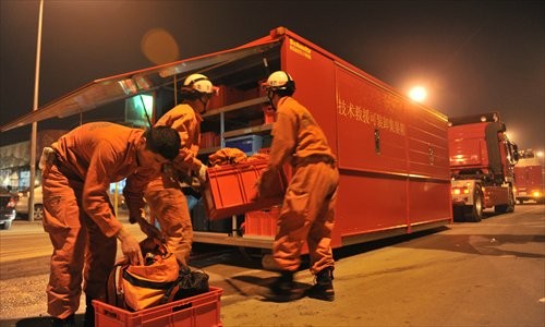 Firefighters rush to the rescue of a man buried in a shaft Monday evening after a cave-in in Haidian district. The man was found dead yesterday, 16 hours after the collapse. 