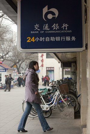 A pedestrian walks past a Bank of Communications branch in Beijing on March 19. [Photo: CFP]