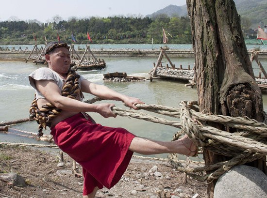 A man fastens a bamboo rope to a tree during the water-releasing ceremony at Dujiangyan, an ancient irrigation project in Southwest China's Sichuan province on Wednesday. The project was built in 256 BC by local governor Li Bing. The ceremony is held every year on Tomb Sweeping Day to pray for favorable weather. (Chen Duo / Xinhua) 