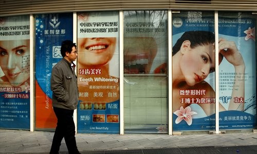 A man walks past a clinic performing plastic surgery yesterday at Guomao, Chaoyang district. [Photo: Guo Yingguang/GT]