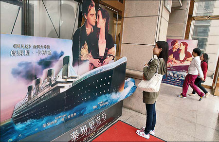 A moviegoer looks at the poster for Titanic 3D at a cinema in Nantong, Jiangsu province, on Tuesday.[Photo/China Daily]