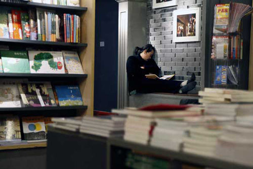 A man sleeps at a branch of Shanghai Popular Bookmall, a 24-hour private bookstore, on Monday. Xiao Junwei / for China Daily