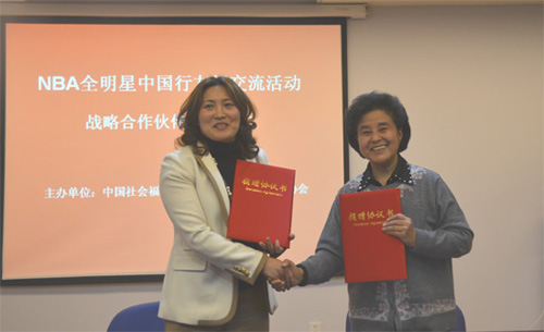 Miao Li (R), vice president and secretary general of the CSWF, shakes hand with Zhou Aiminpresident of the ACSA, at the signing ceremony of the strategic cooperation partnership agreement on NBA Goodwill Clinic Tours of China in Beijing on April 11, 201