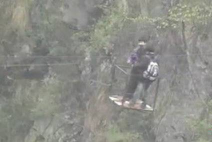 Children use a ropeway to cross Xuandongzi Canyon. [Photo: voc.com.cn]