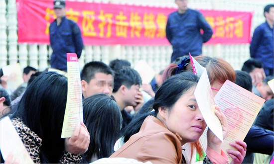 Suspects cover their faces while being instructed to remain in a crouched position during a police crackdown on pyramid schemes on April 7. 