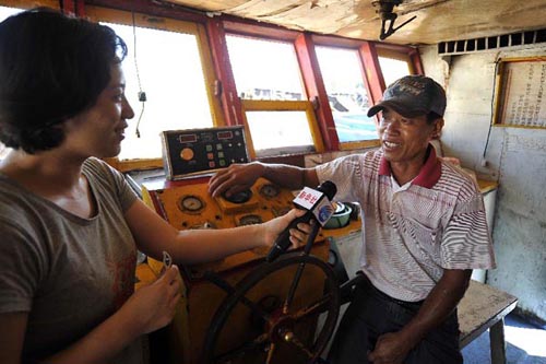 Xu Detan (R), captain of one fishing boat seeking refuge from bad weather at a lagoon off the Huangyan Island days ago, receives interview from Xinhua News Agency in Qionghai City, south China's Hainan Province, April 15, 2012.  (Xinhua/Guo Cheng)