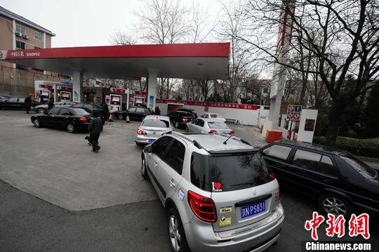 Cars queue up at a petrol station ahead of the price hike in Beijing on March 19, 2012. The retail price of 93 RON rose to 8.33 yuan per liter the followin day.