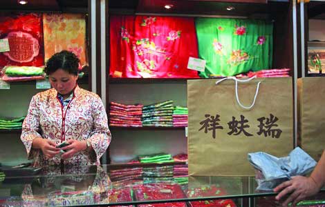 A sales assistant at a Ruifuxiang store in Beijing. Ruifuxiang, a time-honored Chinese silk shop, also sells ready-to-wear clothes, giving more choices to customers. [Photo / Provided to China Daily]