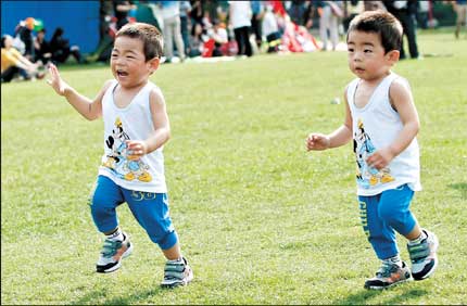 Twins get out and about in the sunshine at Zhongshan Park yesterday.
