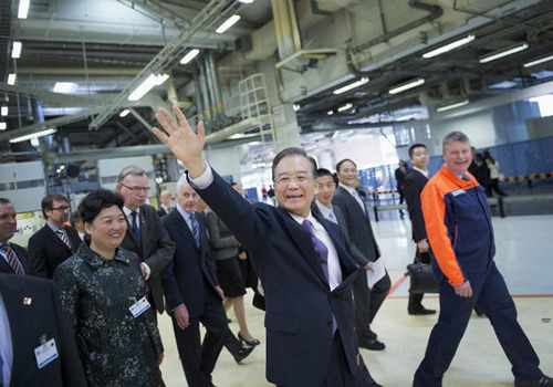 Premier Wen Jiabao waves to employees during his visit to the Volvo factory in Gothenburg, Sweden, on Tuesday. [Photo/Agencies]