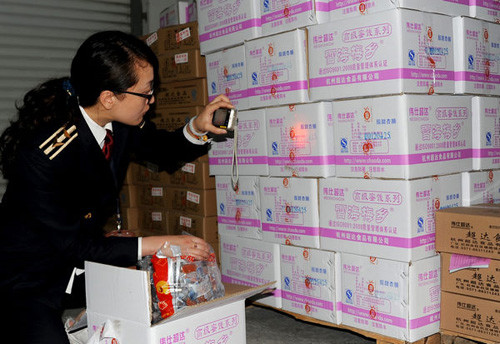 A worker from the quality watchdog checks boxes of preserved fruit at a manufacturer in Hangzhou, Zhejiang Province, on Tuesday. The production date was shown as Wednesday. [Photo: Meng Yiming / China Daily]