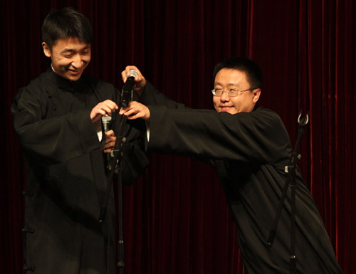 Jiang Xiao (right) performs cross talk with his partner at Renmin University of China in Beijing on April 23. [Photo: Liu Zhe / China Daily]