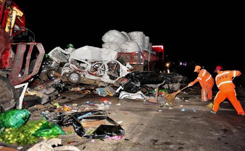 Workers clean the spot of traffic accidents on the Shankun Expressway in Yiliang County, southwest China's Yunnan Province, late May 5, 2012. Twelve people were dead and 19 others injured in two accidents happening on the Shankun Expressway in Yiliang Cou