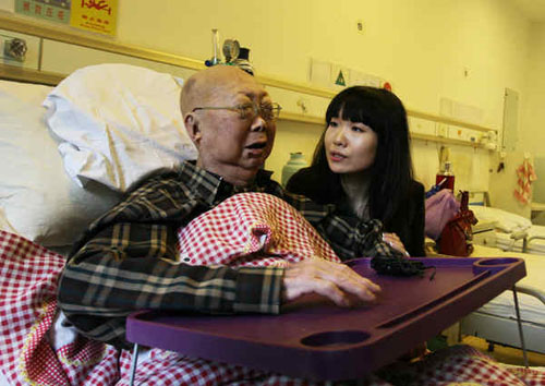 Ling Yifan accompanies her grandfather, who was diagnosed with lymph cancer three months ago, at a hospital in Beijing on Monday. Ling initiated the Taking Grandpa Around the World campaign to ask netizens to help her grandfather fulfill his dream of traveling around the world. Wang Ying / for China Daily