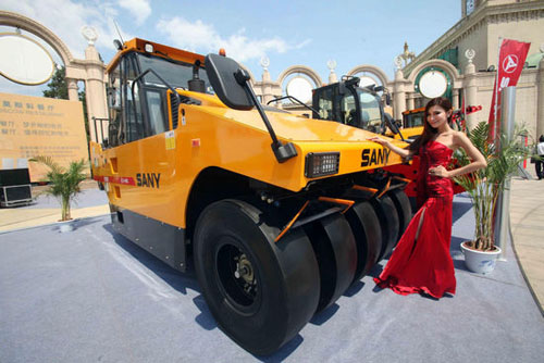 A model poses with a road-roller during the 11th China International Exhibition on Transport Technology & Equipment (CHINA TRANSPO 2012), Beijing, May 15, 2012. CHINA TRANSPO 2012 kicks off at the Beijing Exhibition Center Tuesday.  More than 400 enterprises from the transportation industry will take part in the four-day long expo. [Photo/Xinhua]