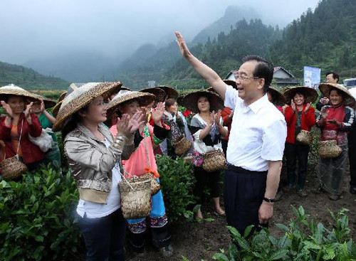 Chinese Premier Wen Jiabao (R, front) waves to tea pickers at the Shutouxi Village of Guzhang County in the Tujia-Miao Autonomous Prefecture of Xiangxi, central China's Hunan province, May 25, 2012.(Xinhua/Pang Xinglei)
