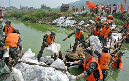 Soldiers of the People's Liberation Army take part in a flood prevention drill in Chaohu city, Anhui province, on Sunday.Li Yuanbo / for China Daily