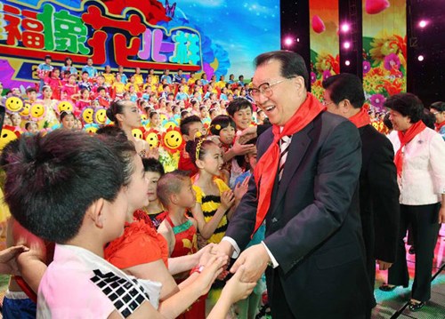 Li Changchun, a member of the Standing Committee of the Political Bureau of the Central Committee of the Communist Party of China, shakes hands with children after attending an evening gala to celebrate the International Children's Day (June 1) in Beijing