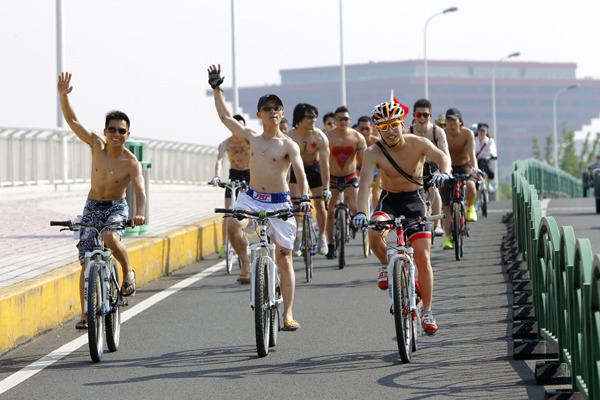 A naked bike-riding activity is held in Shanghai to promote healthy lifestyle and zero-carbon transportation. [Gao Erqiang / China Daily]