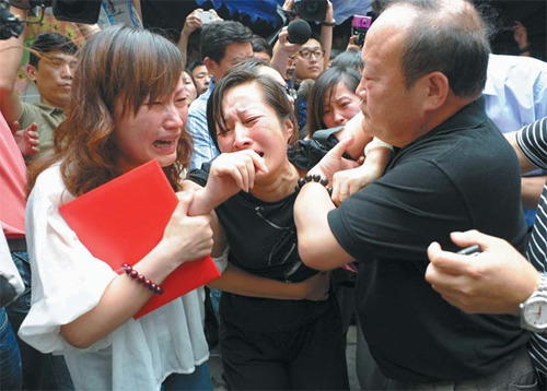 Bus driver Wu Bin's wife, Wang Lizhen (center), and relatives are overwhelmed by grief on Sunday. Wu's bravery captured the public's imagination.  Dong Xuming / for China Daily