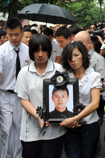 Family members of the late bus driver Wu Bin carry Wu's portrait in Hangzhou, capital of east China's Zhejiang Province, June 4, 2012. Thousands of people bid farewell on Monday to the bus driver Wu Bin, who saved 24 of his passengers after being fatally injured by a piece of metal that flew through his bus's windshield. (Xinhua/Huang Zongzhi)