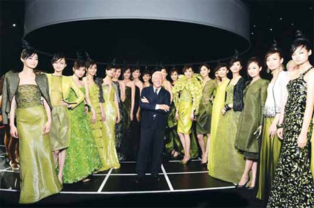 Giorgio Armani, founder and head of the Armani Group, poses with models during the fashion show in Beijing. [Provided to China Daily]