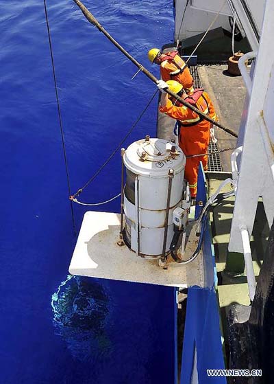 Crew members aboard the Haiyang-6 research vessel retrieve a research equipment set from 6,950 meters below the surface of the Pacific Ocean, June 11, 2012. (Xinhua/Zhou Wenjie) 